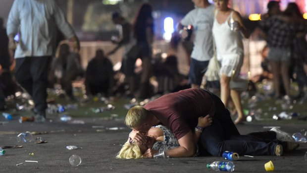 People lie on the ground at a country music festival in Las Vegas after a shots were fired at the concert.