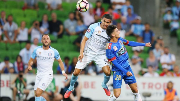 Flying high: Tim Cahill of the City heads the ball over John Koutroutmbis of the Jets for a goal.