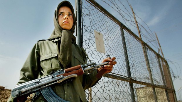 A female fighter of the MEK stands guard at a gate outside their main base at Camp Ashraf, Iraq, 100 kilometres north of Baghdad, in 2003. Residents were transferred to Camp Liberty in 2012.