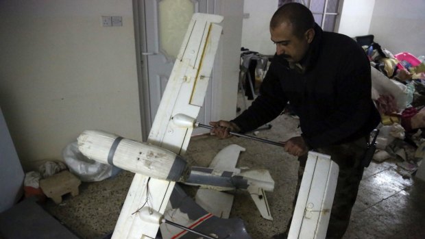 An Iraqi officer inspects drones belonging to Islamic State militants in Mosul.