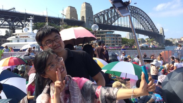 Jonas Cai and wife Freya Cai take a photo with a selfie stick at The Rocks on New Year's Eve. 