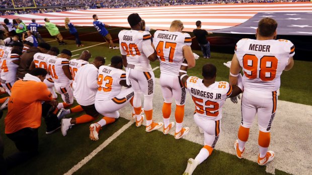 Members of the Cleveland Browns take a knee during the national anthem; players from many NFL teams did the same.