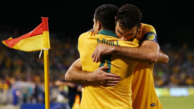 Tim Cahill and Mile Jedinak celebrate a Socceroos goal at Canberra Stadium.