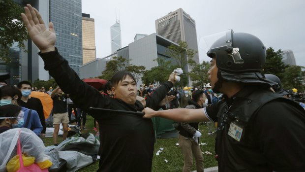 Ready for riot: A pro-democracy protester and policeman outside government headquarters in Hong Kong.