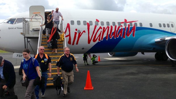 Passengers arrive at Port Vila airport after a flight from Sydney.