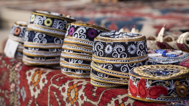 Taqiyah, traditional muslim hats placed on a typical carpet sold on a local market in Icheri Sheher (Old Town) in the Center of Baku. 