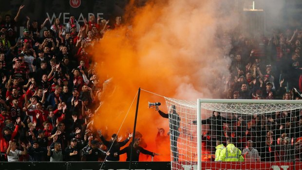 A flare is lit amongst Wanderers fans during the match between the Wanderers and Perth Glory.
