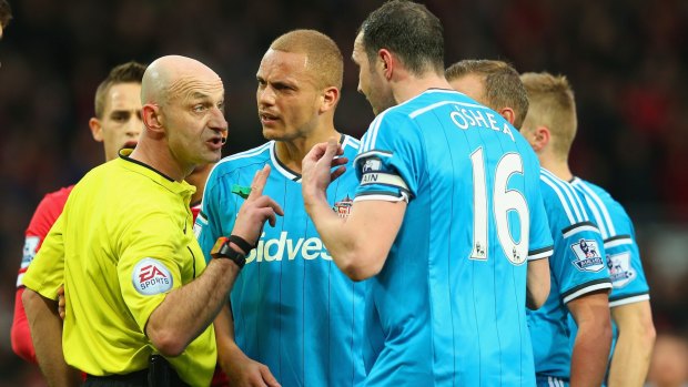 Wes Brown and John O'Shea argue with referee Roger Earl after Brown was mistakenly shown a straight red.