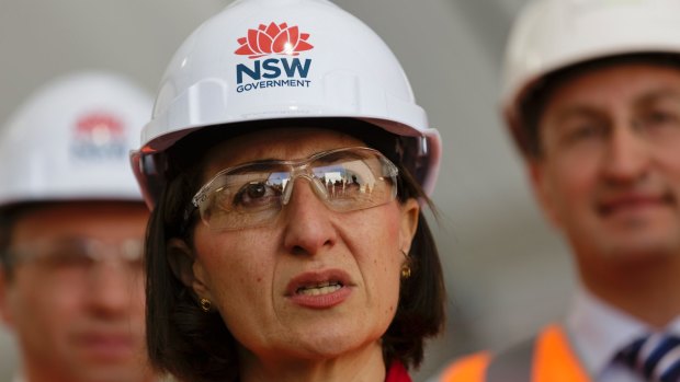 Premier Gladys Berejiklian, in a hard hat bearing the NSW government waratah logo.