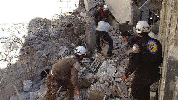 Syrian Civil Defense workers (known as White Helmets) search through the rubble after air strikes in the village of Hass in the Idlib province, Syria.