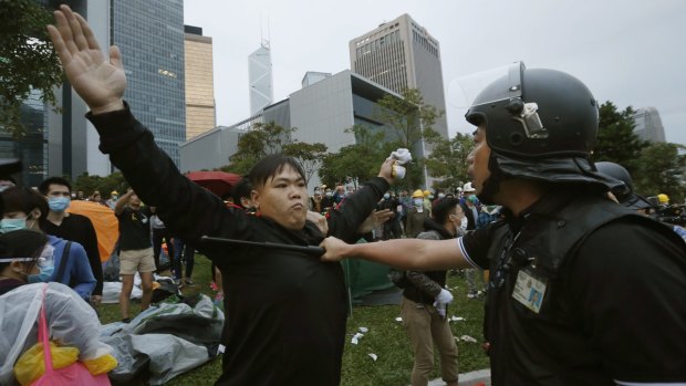 Clash: A pro-democracy protester and a policeman outside the government headquarters in Hong Kong.