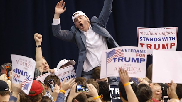 A supporter of Republican presidential candidate Donald Trump tries to pump up the crowd before the Chicago rally was cancelled on Friday.