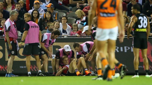 Nick Riewoldt is helped by trainers after the collision.