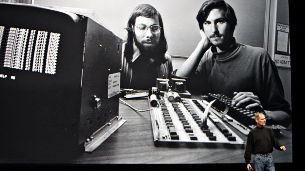 Steve Jobs speaks in 2010 before an image of himself and Steve Wozniak with the Apple I Computer they made from borrowed Atari parts.