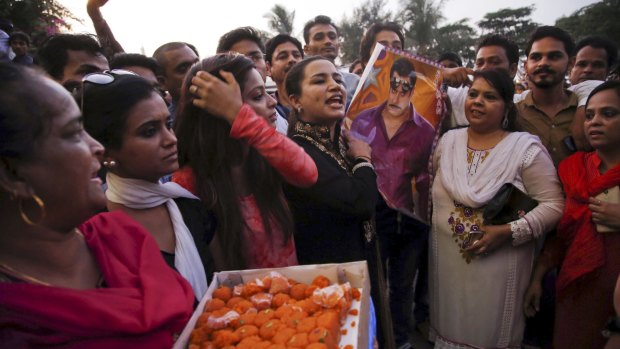 Fans hold a poster of Bollywood star Salman Khan and distribute sweets outside his house to celebrate his acquittal in December last year.