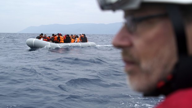 A German rescuer volunteer escorts a dinghy with refugees and migrants as they arrive from the Turkish coast on the Greek island of Lesbos, on Friday.