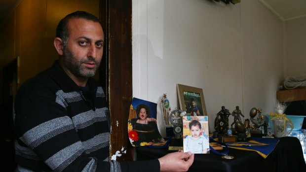 Azzam Hrouk holds a photo of his murdered son Mahmoud.