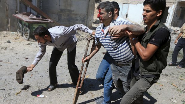 Men help an injured civilian after what activists said were air strikes by forces loyal to Syrian President Bashar al-Assad on a busy marketplace in the Douma neighbourhood of Damascus on August 12.