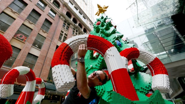 Finishing touches: Johnno Austin puts the final bricks in the Pitt Street Mall Lego Christmas tree.