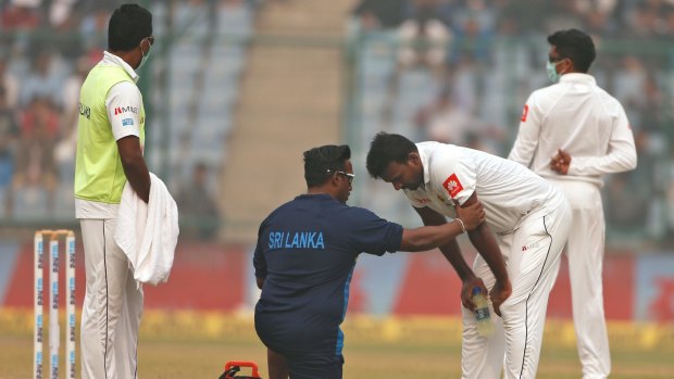 A paramedic speaks to Sri Lanka's Lahiru Gamage after he complained of short of breath.