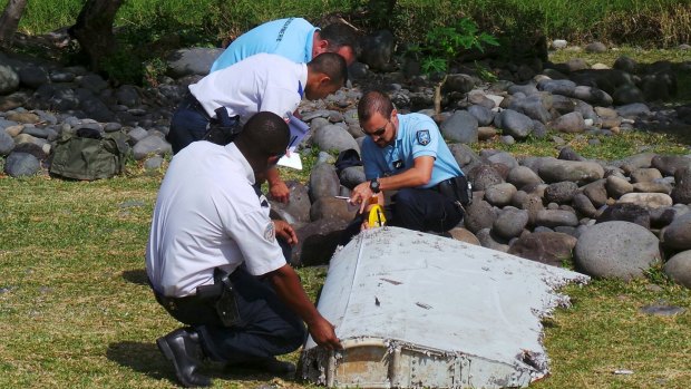 French police inspect the flaperon, now confirmed to be from MH370, on Reunion Island.
