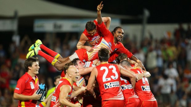  Liam Patrick (top) of the Suns celebrates with Karmichael Hunt (obscured) and teammates after the famous win over Richmond.