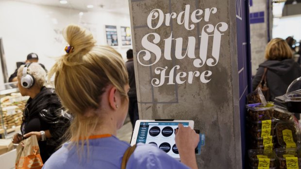 A customer uses a tablet computer to place an order at the new Whole Foods Market in Los Angeles.