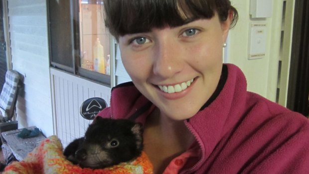 Biologist Emma Peel with a young Tasmanian devil. 