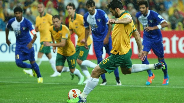Positive start: Mile Jedinak winds up from the penalty spot to extend the Socceroos' lead against Kuwait in the Asian Cup opener.
