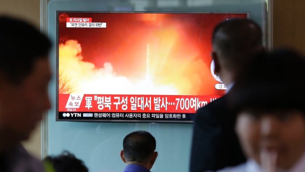 South Korean commuters at Seoul Railway Station watch footage of this week's missile launch.