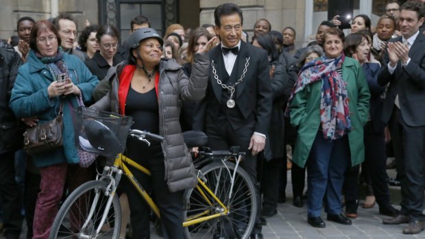 Christiane Taubira leaves the French Justice Ministry on a bike on Wednesday, after her resignation was accepted.