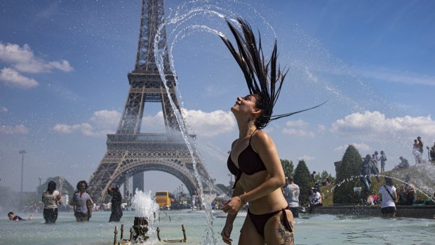 A girl cools down in the fountains of Trocadero, across from the Eiffel Tower, during a heatwave in Paris last year.