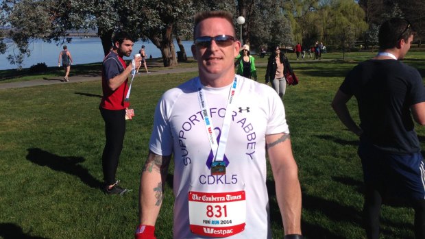 Trevor Dell competed in the Canberra Times fun run in the hope of meeting then Chief Minister Katy Gallagher. He is wearing the T-Shirt he had made to raise awareness of his daughter's condition.