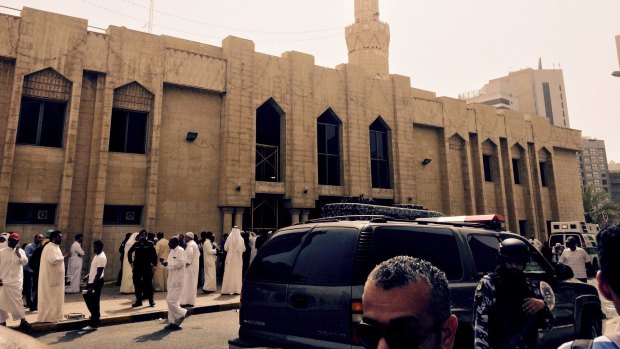 Police control the crowd in front of the Imam Sadiq Mosque after a bomb explosion, in the Al Sawaber area of Kuwait City.