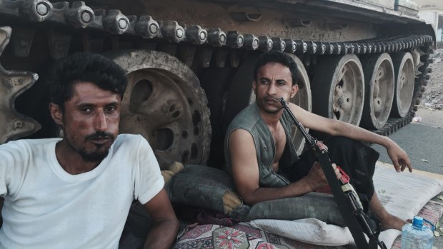 Militia loyal to Yemen's President Abed Rabbo Mansour Hadi rest near their tank on Saturday. 
