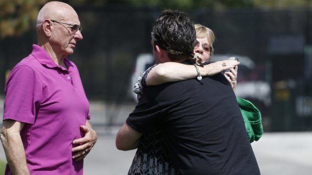 Sandy Phillips, right, whose daughter Jessica Ghawi was killed in the 2012 attack, hugs Eric McQuinn, brother of Matt McQuinn, who was also killed.