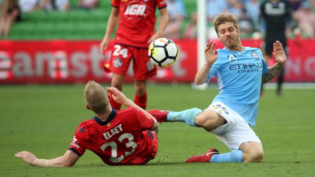 Luke Brattan of Melbourne City goes down in a tackle from Jordan Elsey of Adelaide.