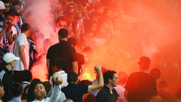 A flare is ignited in the Melbourne Victory supporters area of the crowd at Saturday's derby match.