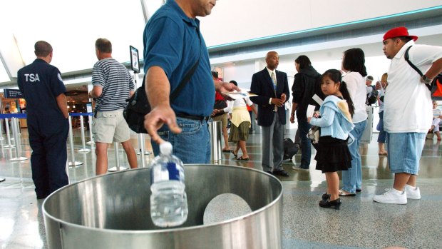 A passenger discards a bottle of water before being allowed to board his flight.