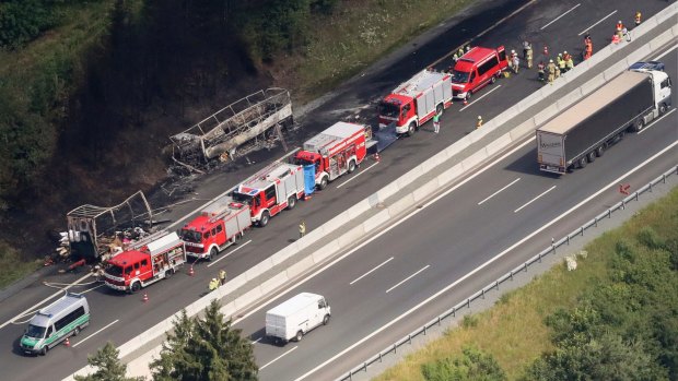 An aerial view shows the site of the accident and the burnt-out bus.