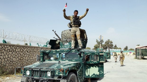An Afghan soldier raises his hands as a victory sign, in Kunduz city, north of Kabul, last month. 