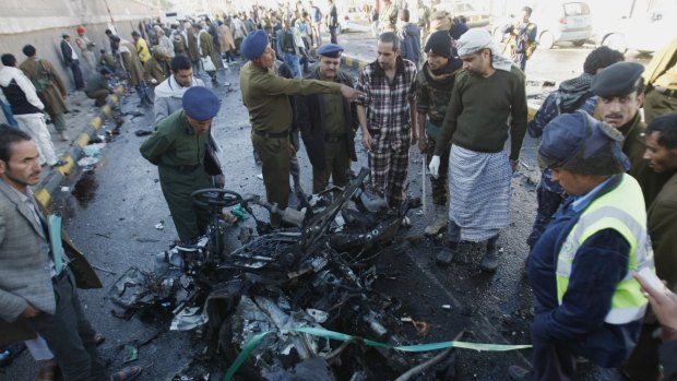 Yemeni investigators inspect wreckage at the scene of the car bombing.