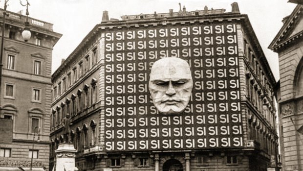 National Fascist Party headquarters, Rome, 1934, decorated with Benito Mussolini's face and the word Si in reference to the Italian general election which took place in the form of a referendum; voters could either accept or reject the Grand Council of the National Fascist Party, 99.84 per cent of voters voted "si". 