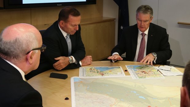 Prime Minister Tony Abbott and ASIO director-general of security inspect the maps.