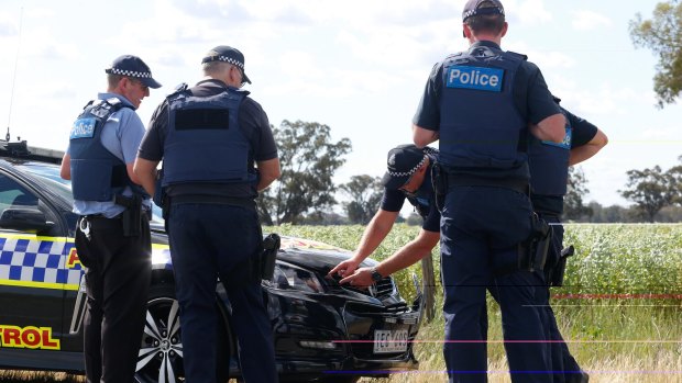 Police inspect the damage to the highway patrol car that was rammed near St James by the wanted father and son on Thursday afternoon.