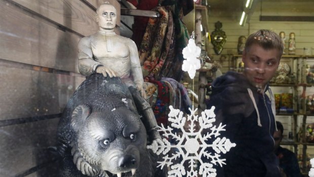 A carved figure depicting Russian President Vladimir Putin sitting on a bear displayed in a gift shop window in St.Petersburg, Russia.