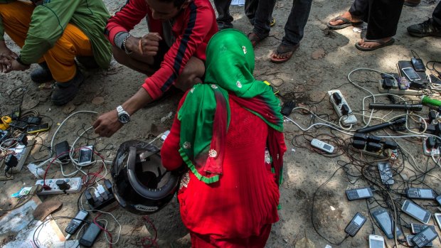 Victims of the earthquake charge their mobile phones on the street in Melamchi, Nepal. 