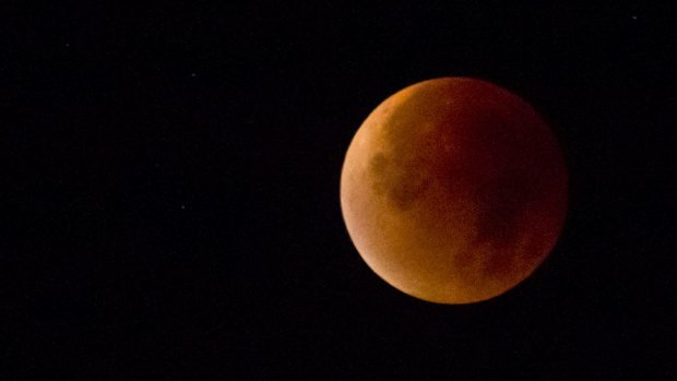 The Earth's shadow obscures the view of a supermoon during a total lunar eclipse over Antwerp, Belgium on Monday.