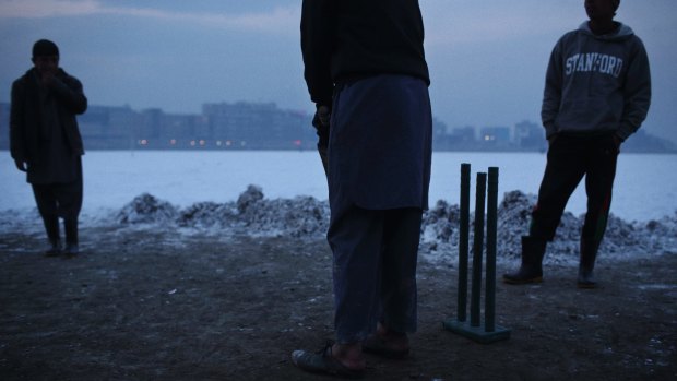Keen for a game: Kabul locals play cricket on a small patch of ground that they cleared of snow.