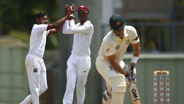 Devendra Bishoo, left, celebrates after taking the wicket of Shane Watson.